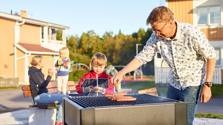 Familj vid en grillplats