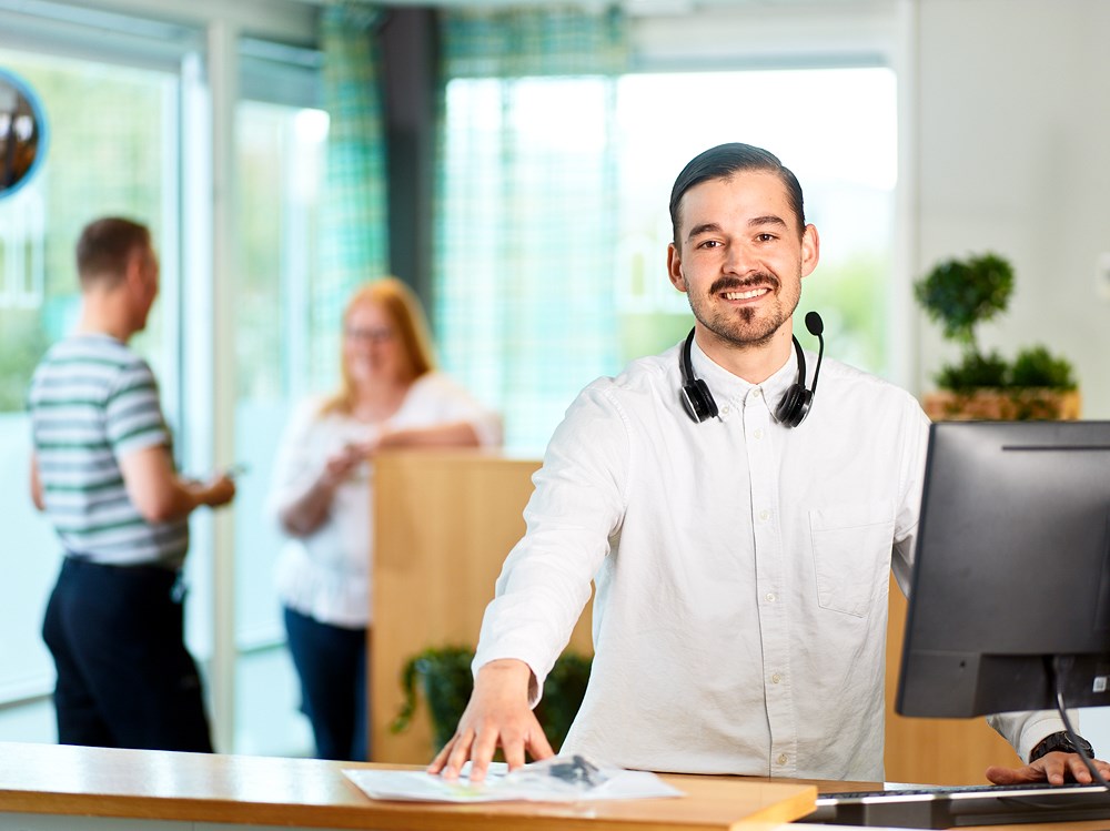 Medarbetare på kundcenter står vid receptionen