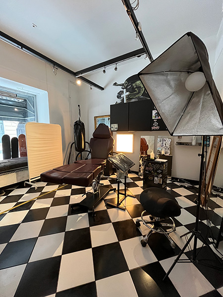 När man går in i lokalen så finns ett stort rum med svart-vitt rutigt golv och vita och grå väggar. Bild.