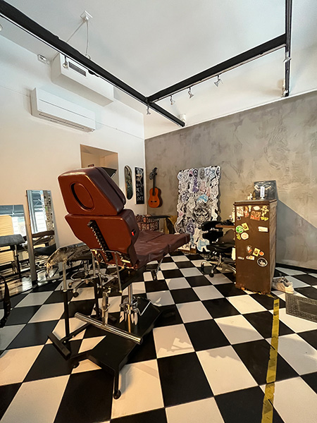 När man går in i lokalen så finns ett stort rum med svart-vitt rutigt golv och vita och grå väggar. Bild.